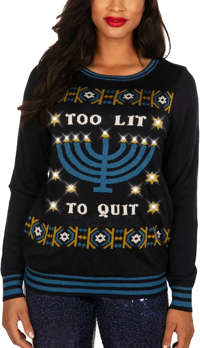 A woman rocks the Too Lit to Quit Hanukkah Sweater—navy, menorah blazing, “Too Lit To Quit” shouting, pure party legend vibes.