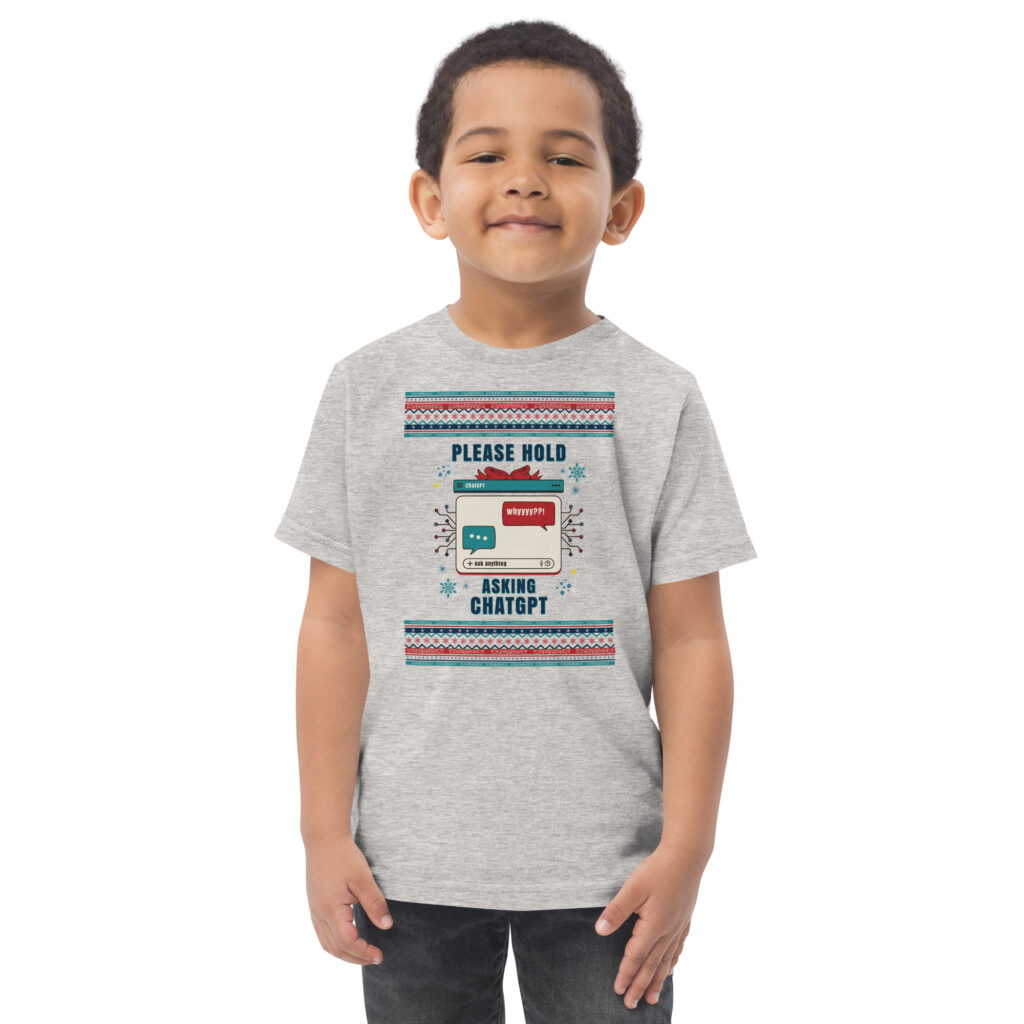 A grinning kid rocks a heather gray tee shouting “PLEASE HOLD… ASKING CHATGPT” with chat boxes. Sassy party vibes in toddler size!