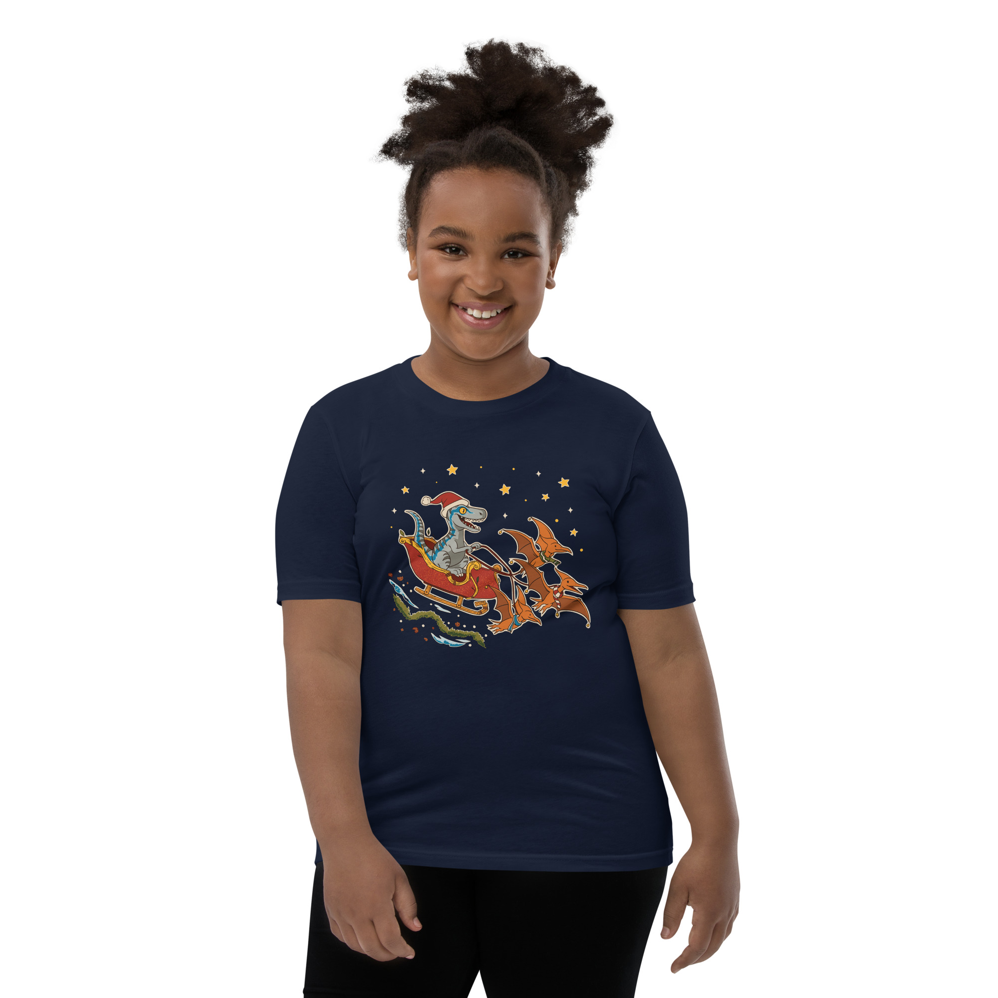 A grinning girl with curly hair rocks a navy tee covered in party-ready dinos, stars, and a moon—gift it or win style points!.